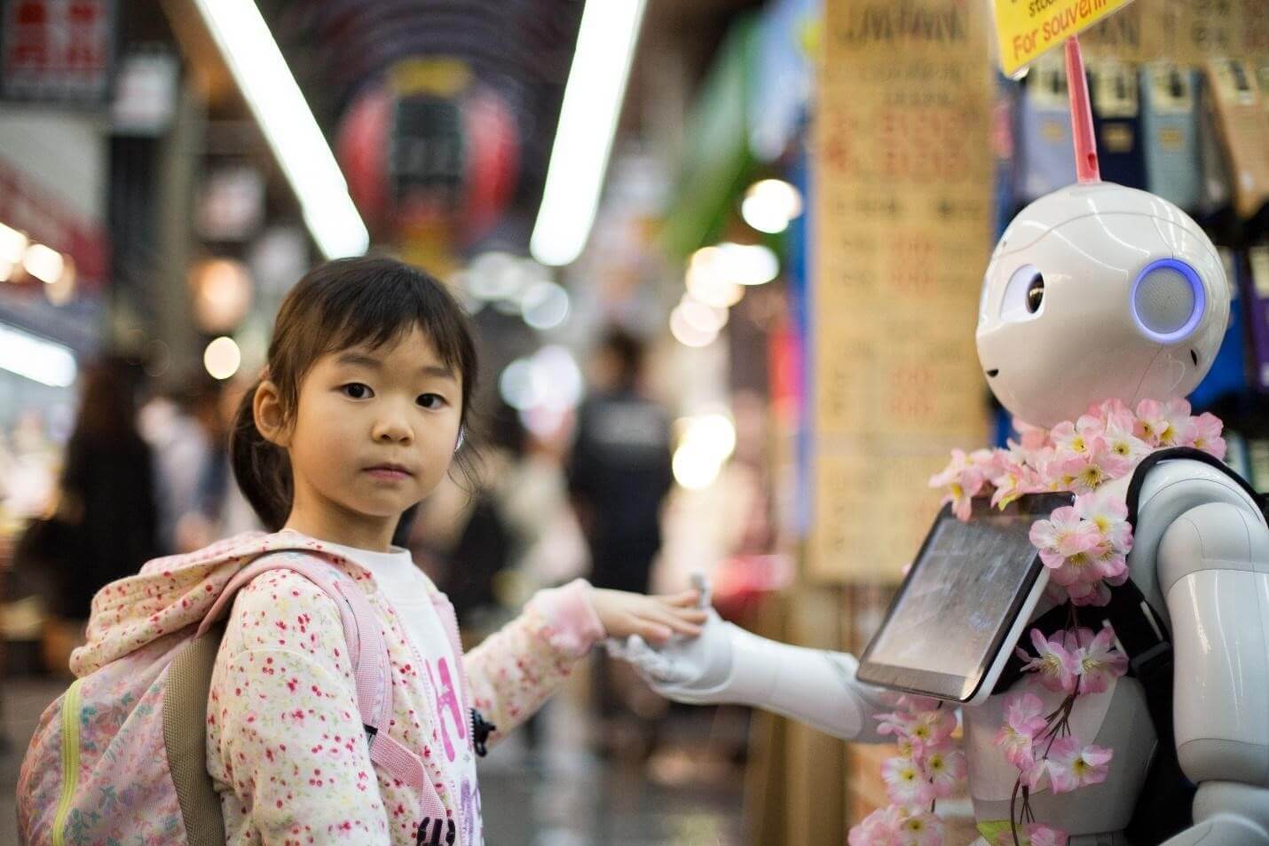 Child holding hands with a robot.
